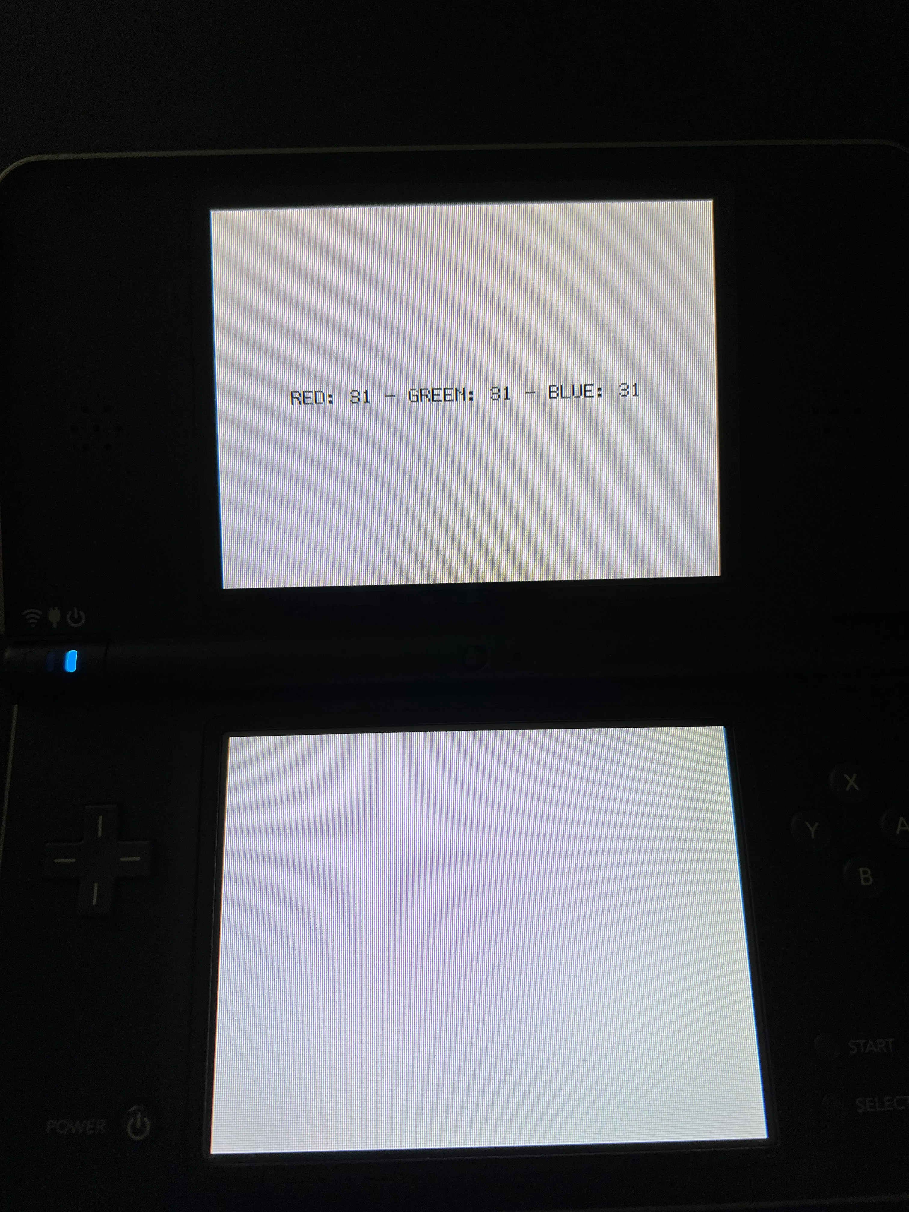 The Nintendo DSi XL console before the experiment, showing a yellow tinted screen.